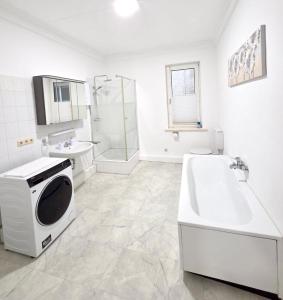 a bathroom with a tub and a sink and a microwave at Ferienwohnung Fleiger 2 in Achim Zentrum in Achim