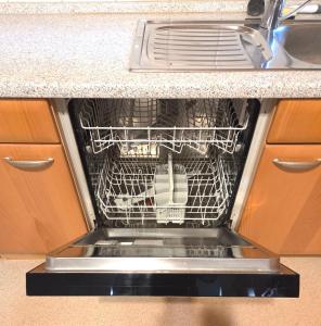 a dishwasher with its door open in a kitchen at Ferienwohnung Fleiger 2 in Achim Zentrum in Achim +14 photos
