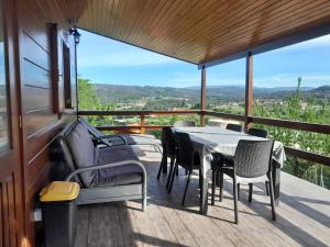 a table and chairs on a balcony with a view at Bungalow da Pedreira in Viseu