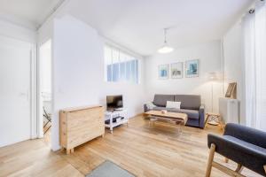 a living room with a couch and a tv at Elegant Central Vincennes Paris in Vincennes