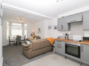 a kitchen and living room with a couch and a table at 76A Mackworth Road in Porthcawl