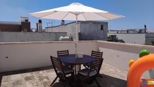 una mesa y sillas con una sombrilla en el techo en Casa Vacanze Livia Maria, en San Cassiano