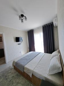 una camera da letto con un letto grande con una finestra di Жана кала 1 комнатная квартира a Türkistan