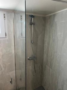 a shower with a shower head in a bathroom at Cozy Kolonaki Retreat in Kremasti +23 photos