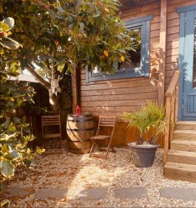 a patio with a tree and chairs and a house at Western style living in Telscombe