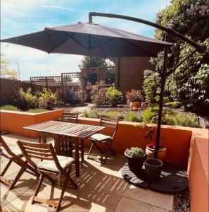 a table and chairs with an umbrella on a patio at Western style living in Telscombe +9 photos