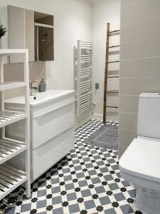 a bathroom with a white sink and a toilet at Maison de famille in Courteuil