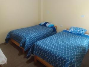 two beds sitting next to each other in a room at Killa Andina Puno in Puno +14 photos
