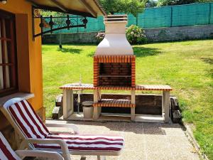 a bench and a table and a vase in a yard at Casona La Zampuca in Gijón