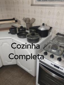 a kitchen with a stove with pots and pans on it at IDEAL Hotel Confort Suite in Piracicaba