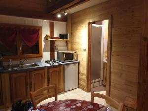a kitchen with a refrigerator and a sink and a microwave at Chalet chez Corinne in Cornimont