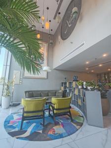 a waiting room with two yellow chairs and a rug at Bram Hotel in Jeddah +70 photos