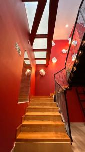 a staircase in a building with red walls and a skylight at Literal Hostel Madrid in Madrid
