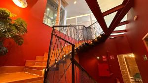 a spiral staircase in a building with red walls at Literal Hostel Madrid in Madrid