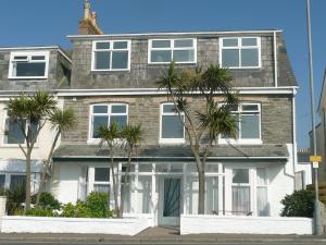 a brick house with palm trees in front of it at The Lyncroft in Newquay