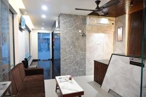 a living room with a couch and a ceiling fan at KK Grand Inn in Vellore