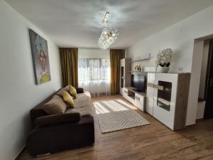 a living room with a couch and a television at Apartament Stefania Targu Ocna in Târgu Ocna