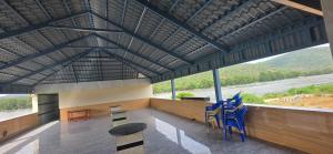 a room with chairs and tables and a large window at CS RESORT River point in Wodapatti