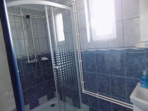 a bathroom with a shower with a glass door at Maksai Vendégház in Ocna de Sus