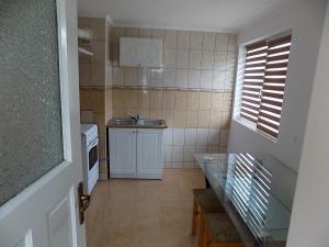 a small kitchen with a sink and a table at Maksai Vendégház in Ocna de Sus +7 photos