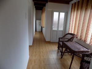 a hallway with two chairs and a table and a door at Maksai Vendégház in Ocna de Sus