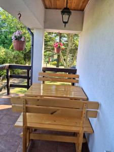 a wooden table and benches on a patio at Mazurski Spokój 