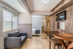 a living room with a couch and a table at Estúdio Modernos em Condomínio com Piscina em Floripa - ASK in Florianópolis