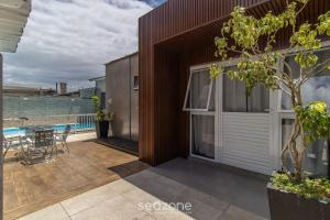 a house with a balcony with a table at Estúdio Modernos em Condomínio com Piscina em Floripa - ASK in Florianópolis