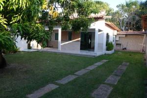 a backyard of a house with a green yard at Casa amarela in Barreirinhas