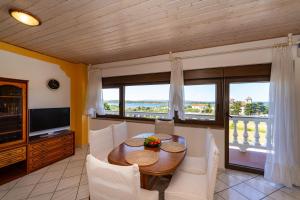 Un comedor con mesa y sillas y un televisor. en Apartments Villa Verica - Mit Meerblick & Pool auf der Insel Rab, en Banjol