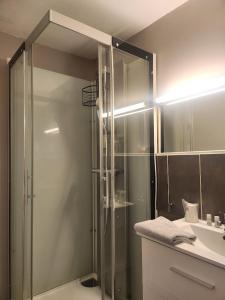 een badkamer met een glazen douche en een wastafel bij Ariane Hôtel in Vichy +32 foto's