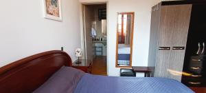 a bedroom with a bed and a hallway with a kitchen at Casa Rosário Centro de Amparo in Amparo