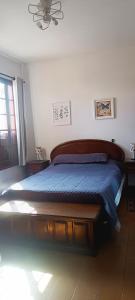 a bedroom with a bed with a blue comforter at Casa Rosário Centro de Amparo in Amparo