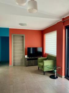 a living room with a green couch and a television at Villa Sangria in Skala Marion