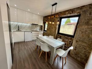 Una cocina y un comedor con mesa y sillas. en Casas Castelhano - Minho Braga, en Mire de Tibães