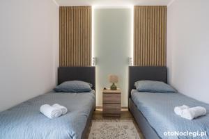 two beds in a bedroom with towels on them at Ilanel Twój azyl nad Jeziorem Charzykowskim in Charzykowy