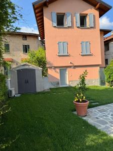 a house with a yard with a plant in the grass at Il Valletto in Bellagio