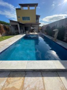 a swimming pool in front of a house at Recanto do Mirante in Fortim