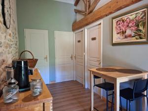 a kitchen with a table and chairs in a room at Chambres d'hotes aux Petits Belézins in Saint-Amour