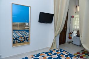Un dormitorio con un espejo, una cama y un televisor. en Casa Ines, en Sant'Agnello