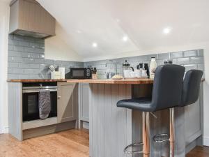 een keuken met een aanrecht met een barkruk bij Fairhead Cottage in Grosmont