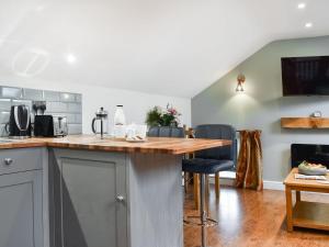 een keuken met een houten aanrecht en een aantal stoelen bij Fairhead Cottage in Grosmont