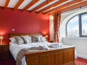 een slaapkamer met een bed en een rode muur bij Fairhead Cottage in Grosmont +8 foto's