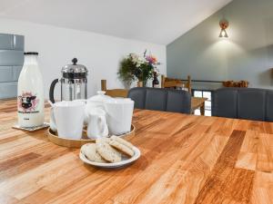 een tafel met koekjes en koffiekopjes erop bij Fairhead Cottage in Grosmont