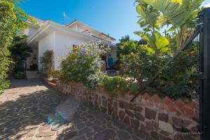 a house with a brick wall and some plants at Villa Alex Relax E Mare in Mondello