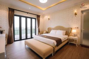a bedroom with a large bed and a large window at Here & Home Villa Vườn Vua in Kon Rung (1) +11 photos