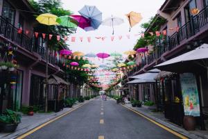 an empty street with umbrellas hanging from buildings at Here & Home Villa Vườn Vua in Kon Rung (1)