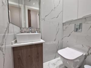 een witte badkamer met een wastafel en een toilet bij Nostra Casa - Tivat in Tivat +8 foto's