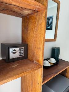 a microwave sitting on top of a wooden shelf at Rafiki Hotel Nungwi Beach in Nungwi