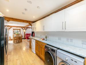 a kitchen with white cabinets and a washer and dryer at The Lodge in Gloucester